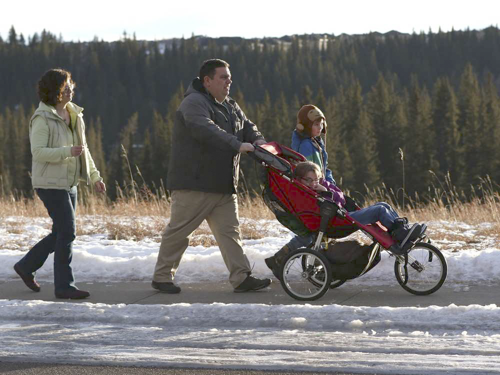 Dave and Pam Francis push their daughter Emma Francis, 12, as their son Noah, 8 walks beside them.