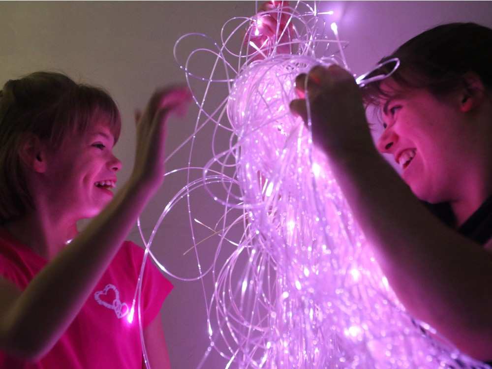 Cally explores the sensory room with Kaitlin Schellenberg, an educational assistant. The room includes strands of fibre optic lights that children can explore to help them communicate and understand their surroundings. Christina Ryan, Calgary Herald.