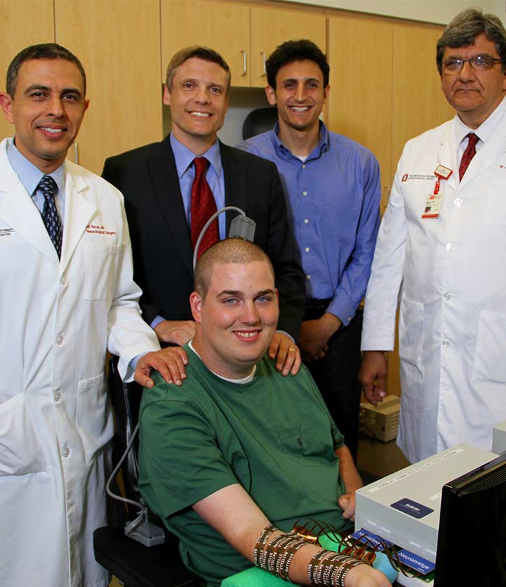 In 2014, Ian Burkhart became the first patient in the world to use neural bypass. The team included, from left, Ali Rezai MD, Chad Bouton, former researcher at Battelle, Nick Annetta, an electrical engineer at Battelle, Milind Deogankar MBBS and Jerry Mysiw MD. 