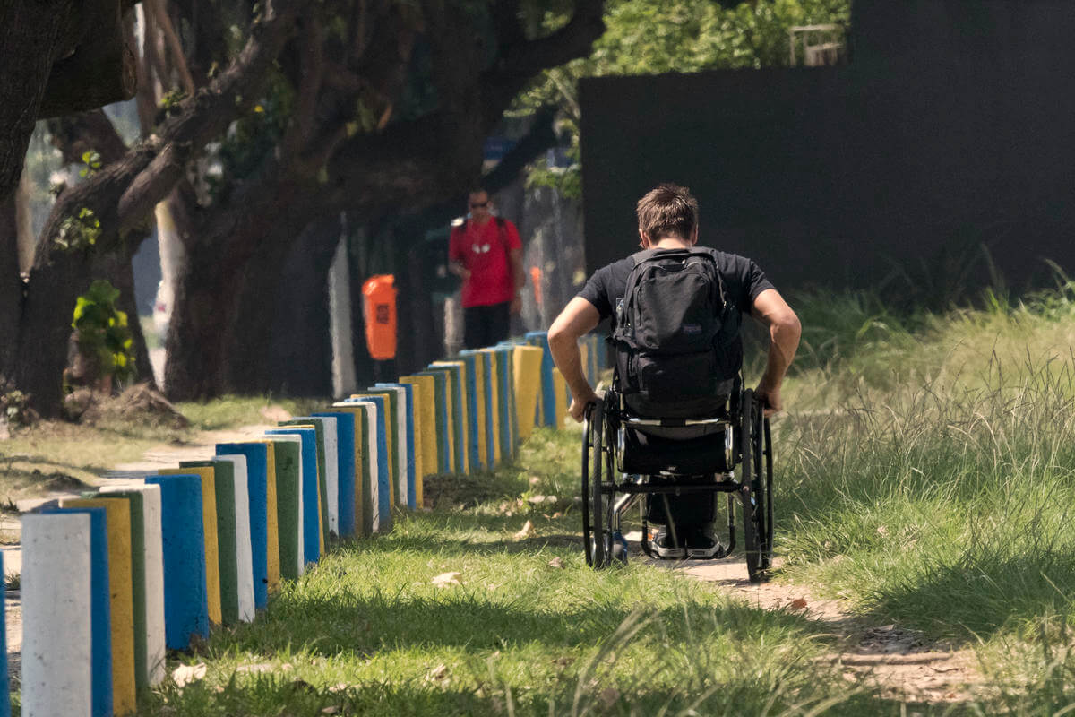 Penn State student Brett Gravatt navigates a dirt path along a sidewalk in Rio