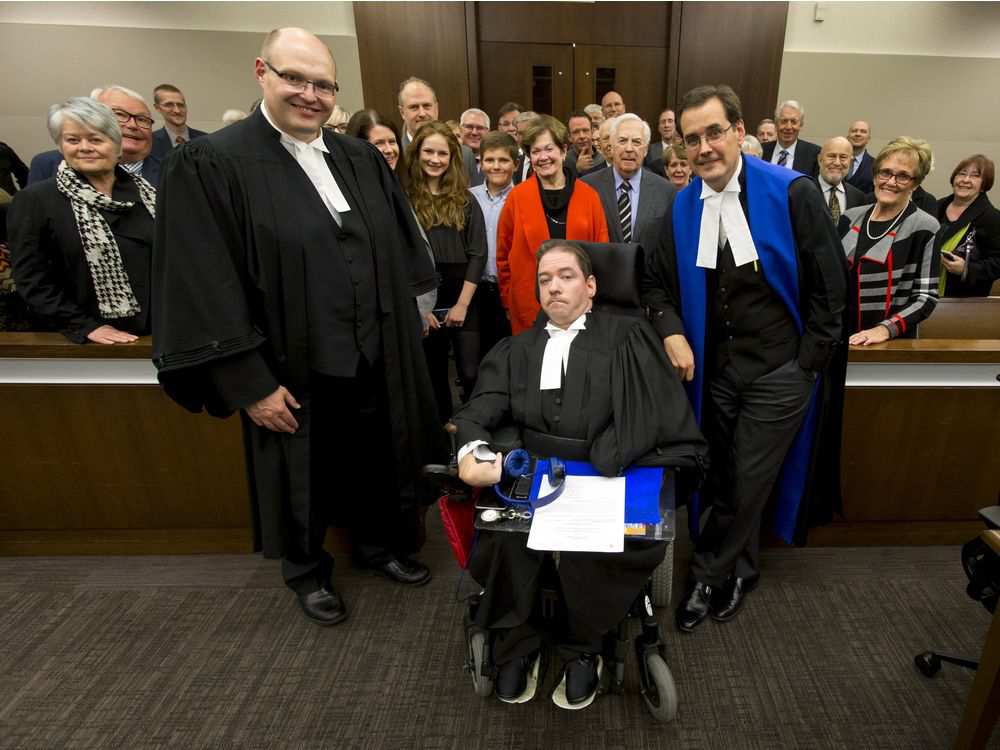 Backed by a gallery of friends and family, Greg McMeekin is flanked by Justice Paul Mason (R) and lawyer Neil Dobson after a ceremony in which he was called to the bar at Calgary Courts Centre in Calgary, Alta., on Tuesday, Oct. 4, 2016.